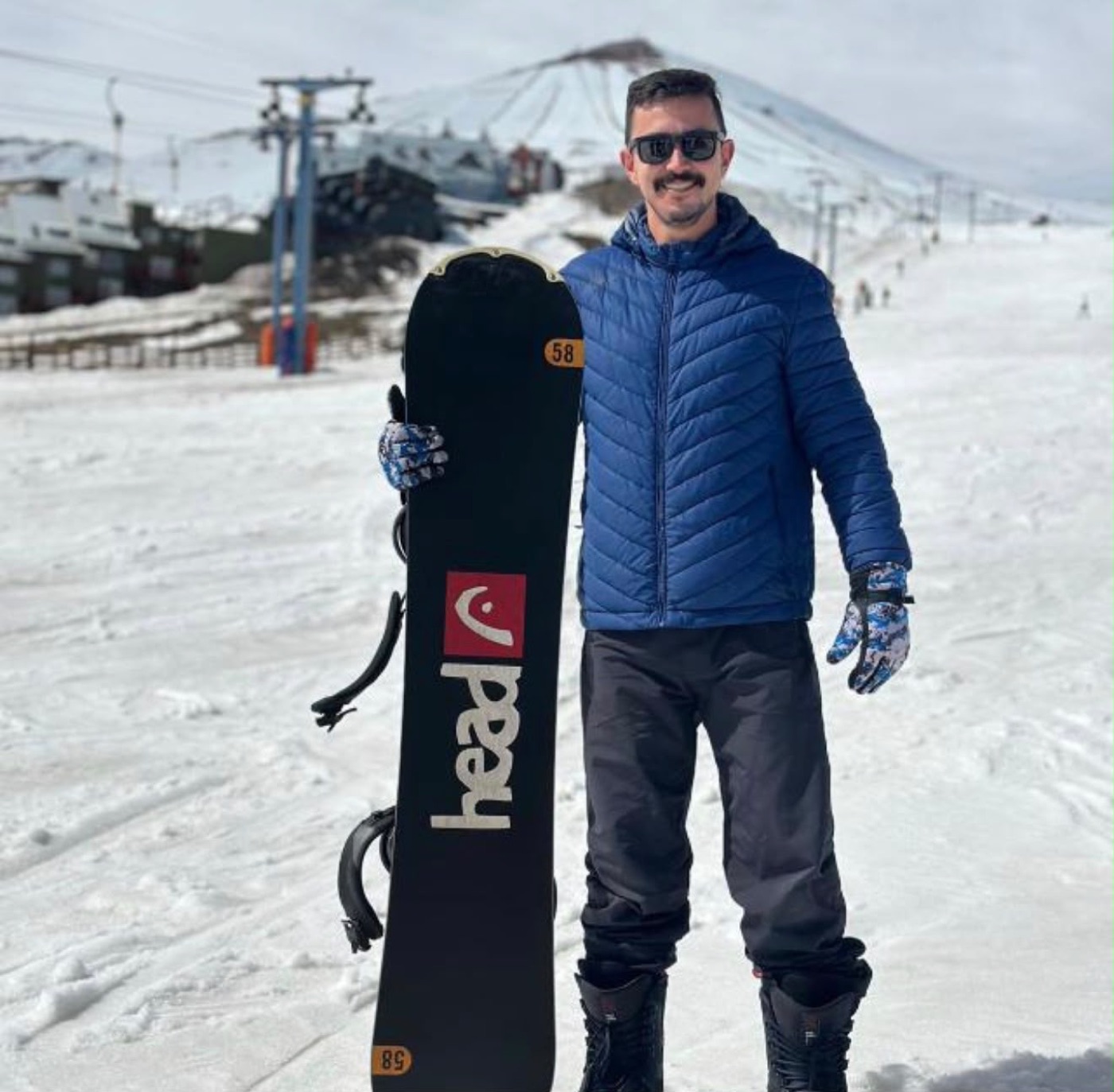 Vinicius na neve, com prancha de snowboard
